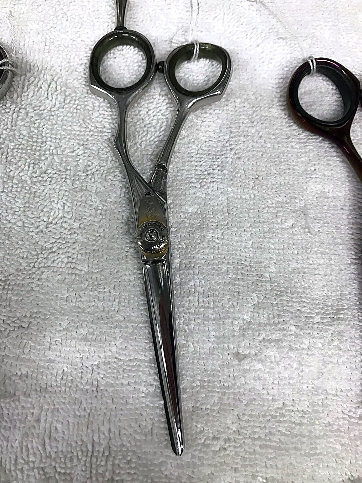 Close-up of a hairdressing scissors handle and finger rings.